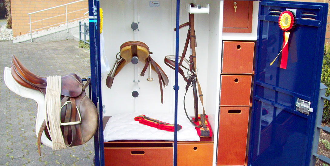Saddle cabinet with lateral foldable saddle holder